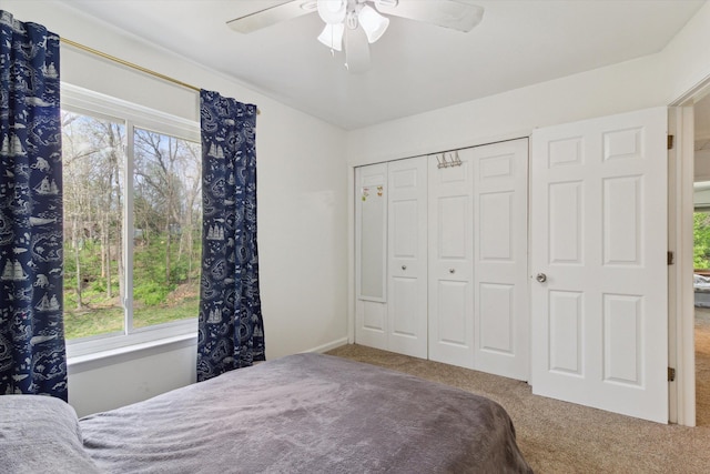 carpeted bedroom featuring a closet and ceiling fan