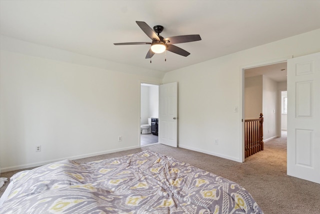 unfurnished bedroom with baseboards, carpet flooring, a ceiling fan, and ensuite bath