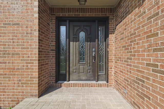 doorway to property featuring brick siding