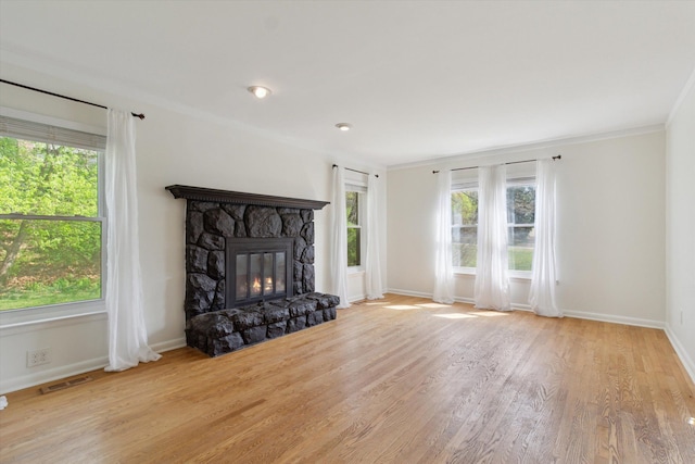 unfurnished living room featuring baseboards, a wealth of natural light, wood finished floors, and visible vents