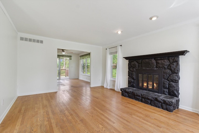 unfurnished living room with baseboards, visible vents, wood finished floors, and a fireplace