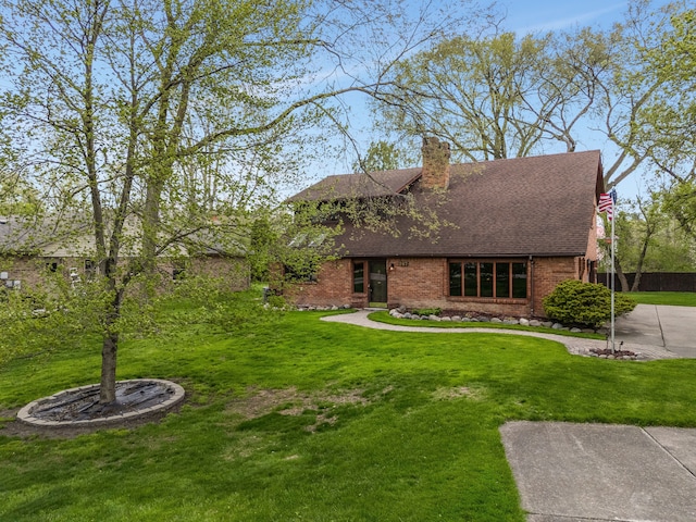 view of front of property with brick siding, a front yard, and roof with shingles