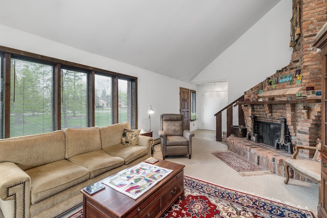 carpeted living area with high vaulted ceiling, plenty of natural light, and a brick fireplace