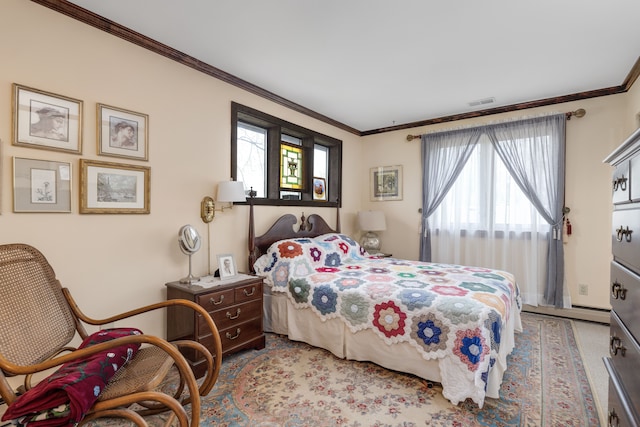 bedroom with visible vents, ornamental molding, a baseboard heating unit, and multiple windows