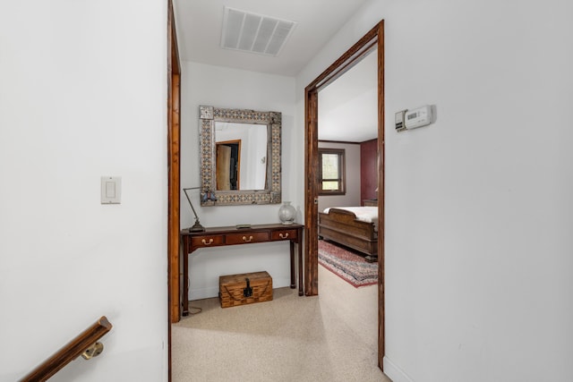 corridor featuring baseboards, visible vents, and carpet