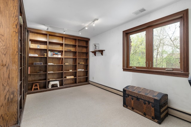 carpeted spare room featuring visible vents and baseboard heating
