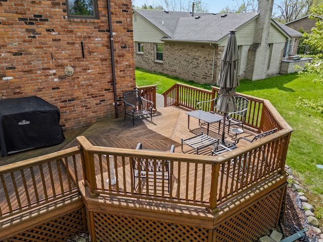 deck featuring a yard and grilling area