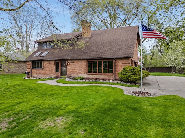 view of front of home with a shingled roof, a chimney, a front lawn, and brick siding