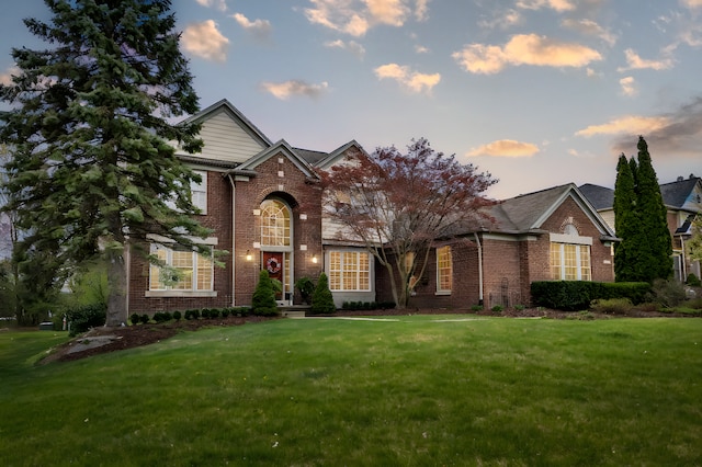 view of front of home with brick siding and a front yard