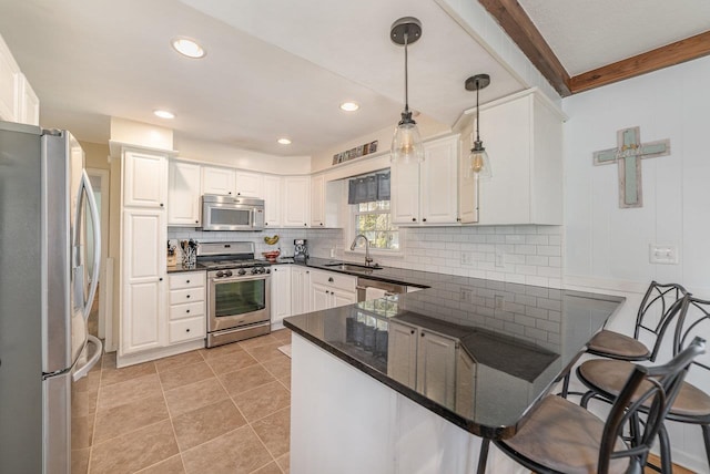 1016 Argyle Ct, Alma, MI 48801 - kitchen with appliances with stainless steel finishes, a sink, a peninsula, decorative light fixtures, and decorative backsplash