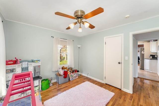1016 Argyle Ct, Alma, MI 48801 - playroom featuring baseboards, ceiling fan, ornamental molding, and light wood-style flooring