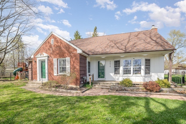1016 Argyle Ct, Alma, MI 48801 - view of front of property featuring a chimney, roof with shingles, brick siding, fence, and a front lawn