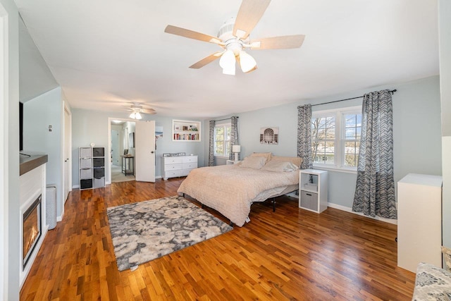 1016 Argyle Ct, Alma, MI 48801 - bedroom with a ceiling fan, baseboards, a glass covered fireplace, and wood finished floors