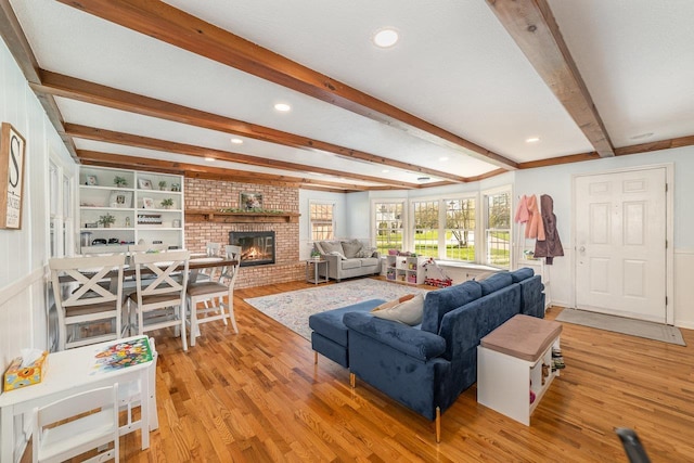 1016 Argyle Ct, Alma, MI 48801 - living room with recessed lighting, beamed ceiling, a brick fireplace, and light wood-type flooring