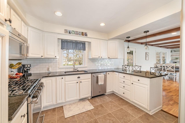 1016 Argyle Ct, Alma, MI 48801 - kitchen featuring a sink, appliances with stainless steel finishes, a peninsula, and a healthy amount of sunlight