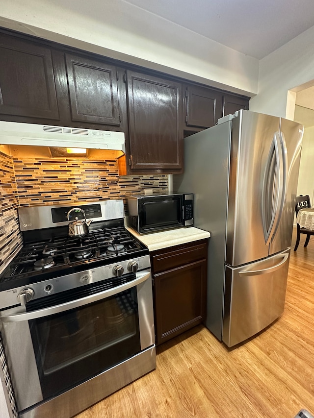 35533 Turner Dr, Sterling Heights, MI 48312 - kitchen with stainless steel appliances, under cabinet range hood, light wood finished floors, and decorative backsplash