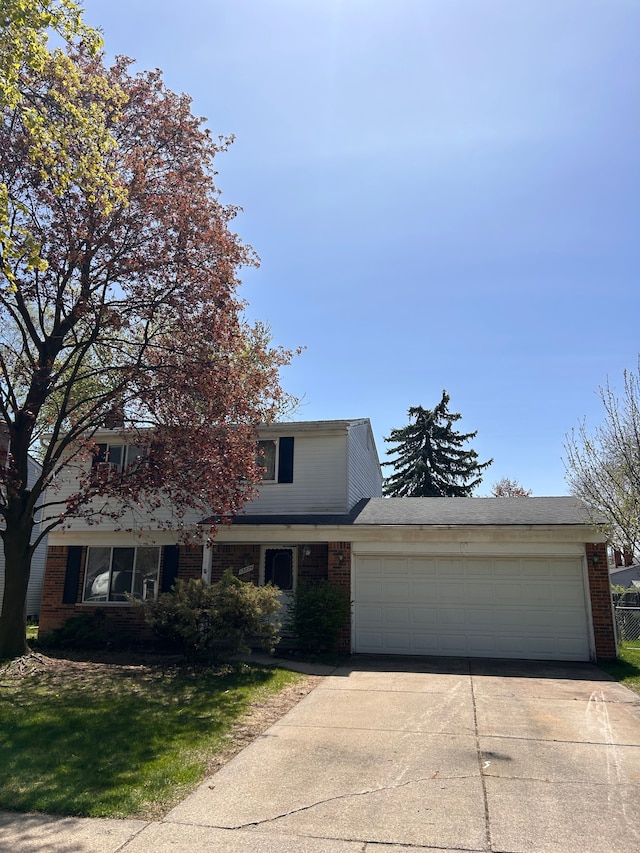 view of front of house with driveway, an attached garage, and brick siding