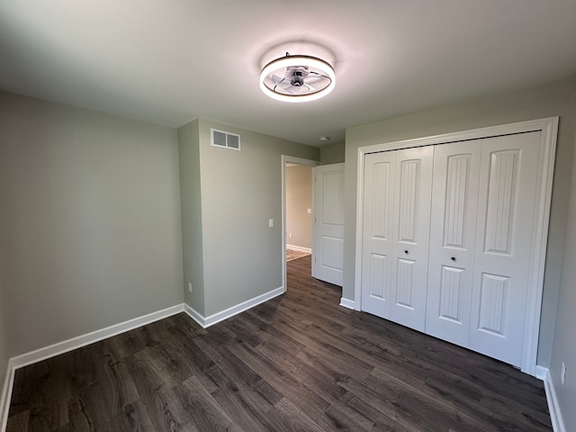 1052 Angle Rd, Lapeer, MI 48446 - unfurnished bedroom with visible vents, baseboards, dark wood-type flooring, and a closet