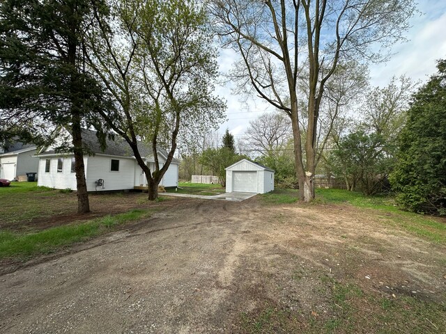 1052 Angle Rd, Lapeer, MI 48446 - view of yard featuring a garage, an outbuilding, and driveway