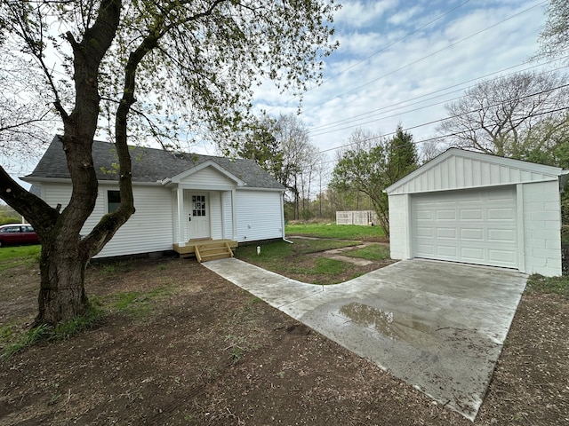 1052 Angle Rd, Lapeer, MI 48446 - view of front of home featuring concrete driveway, an outdoor structure, roof with shingles, and a garage
