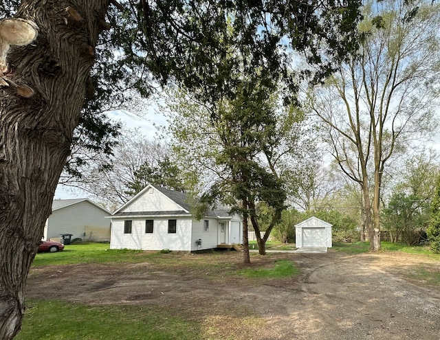 1052 Angle Rd, Lapeer, MI 48446 - view of front facade with dirt driveway, an outbuilding, and a detached garage