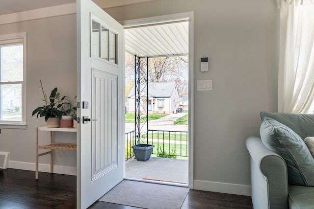 foyer with baseboards, dark wood finished floors, and visible vents