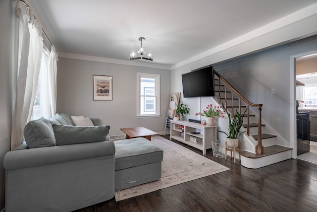living area featuring crown molding, dark wood finished floors, stairs, and a notable chandelier