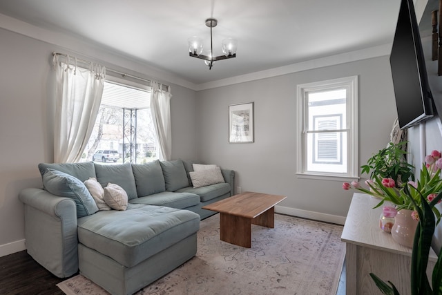 living room with baseboards, a chandelier, and wood finished floors