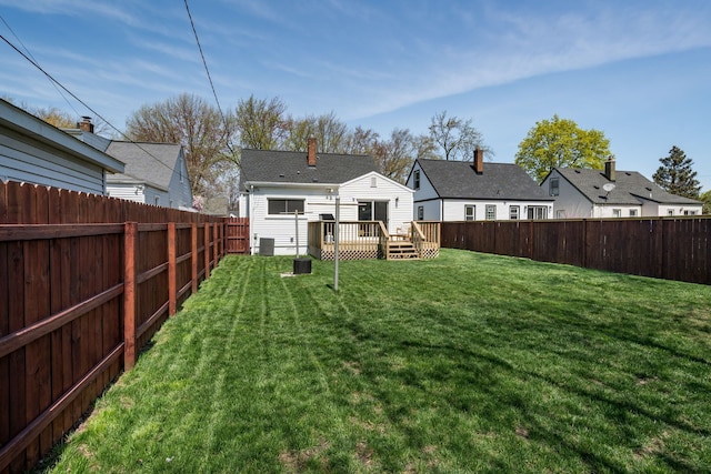 view of yard featuring a deck, a residential view, and a fenced backyard
