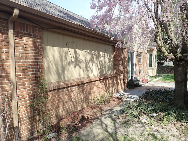 46980 Country Ln Unit 8, Macomb, MI 48044 - view of side of property featuring brick siding, a shingled roof, and a patio area