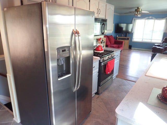 46980 Country Ln Unit 8, Macomb, MI 48044 - kitchen featuring ceiling fan, stainless steel appliances, open floor plan, white cabinetry, and dark tile patterned flooring