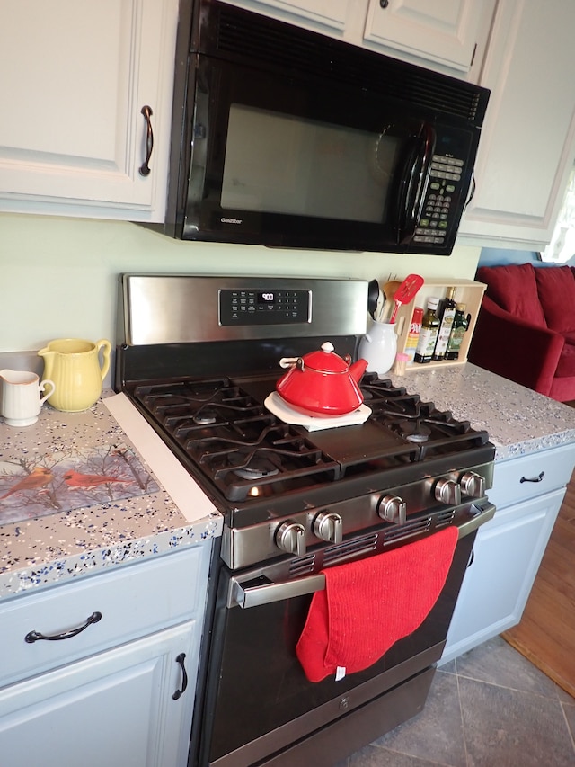 46980 Country Ln Unit 8, Macomb, MI 48044 - kitchen with white cabinets, black microwave, and gas stove