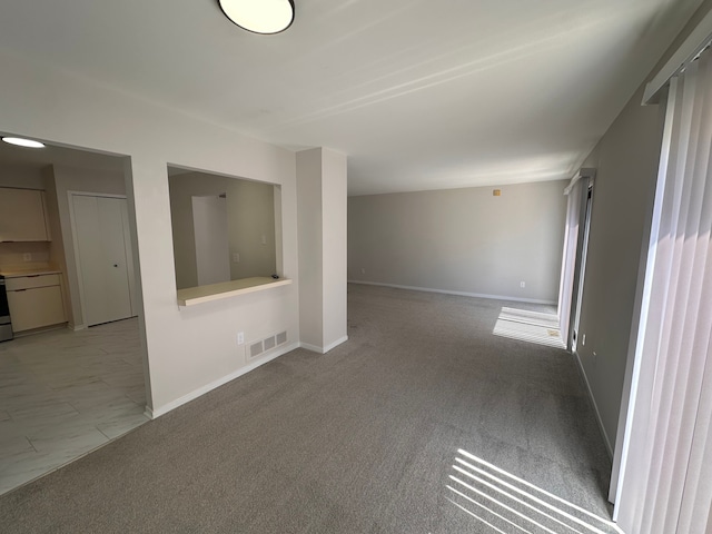 empty room with baseboards, light carpet, and visible vents