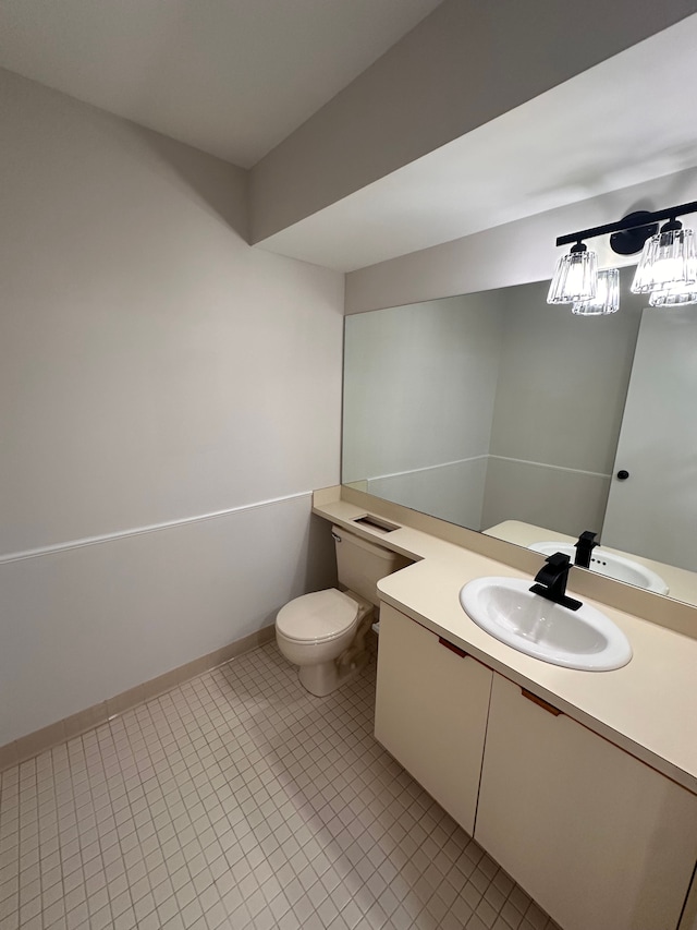 half bath featuring vanity, tile patterned flooring, baseboards, and toilet