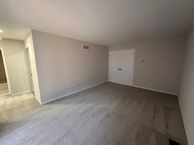 carpeted empty room featuring baseboards and visible vents
