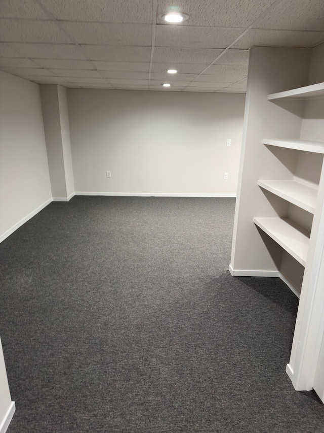 finished basement featuring recessed lighting, baseboards, dark colored carpet, and a paneled ceiling