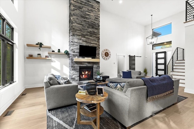 living room featuring a high ceiling, visible vents, and a healthy amount of sunlight