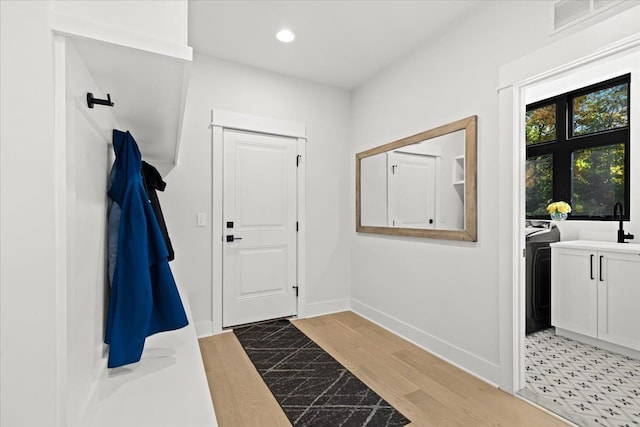 mudroom with light wood-style flooring, recessed lighting, baseboards, washer / dryer, and visible vents