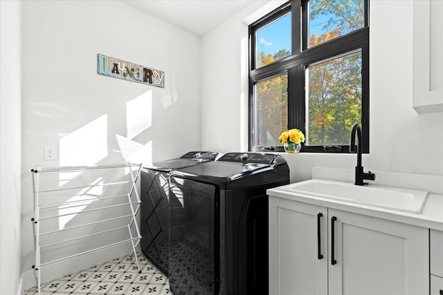 laundry room with a sink, light floors, laundry area, and washer and dryer