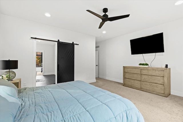 carpeted bedroom with ceiling fan, a barn door, recessed lighting, baseboards, and visible vents