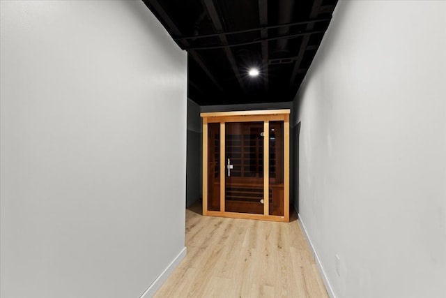 hall with baseboards and wood finished floors