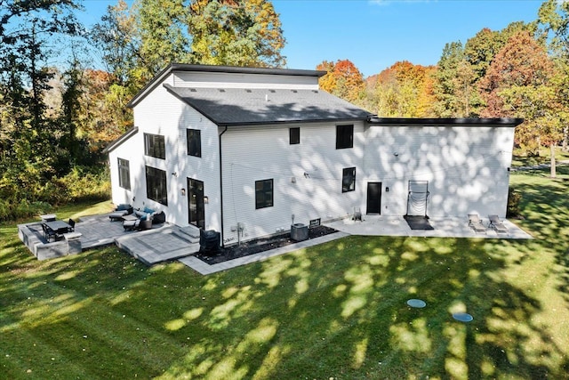back of property with a lawn and a patio area