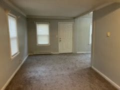 empty room featuring baseboards and carpet
