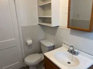 23217 Helen St, Southfield, MI 48033 - bathroom with toilet, vanity, tile walls, and decorative backsplash