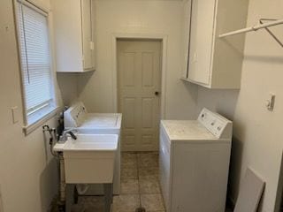 clothes washing area featuring independent washer and dryer, cabinet space, and light tile patterned floors