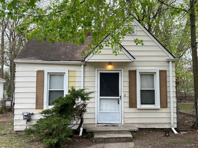 view of front of house with fence, roof with shingles, and entry steps