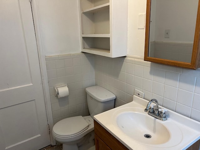 half bath with tile walls, toilet, vanity, and tasteful backsplash