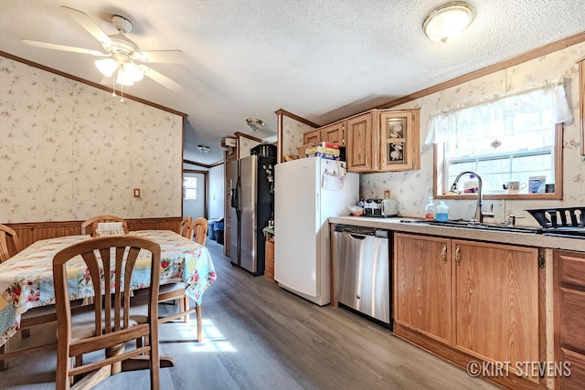 kitchen featuring crown molding, appliances with stainless steel finishes, and wallpapered walls