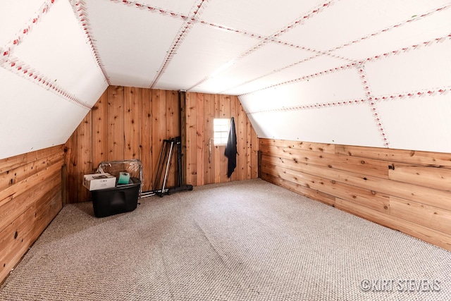 bonus room featuring wood walls, carpet, and vaulted ceiling