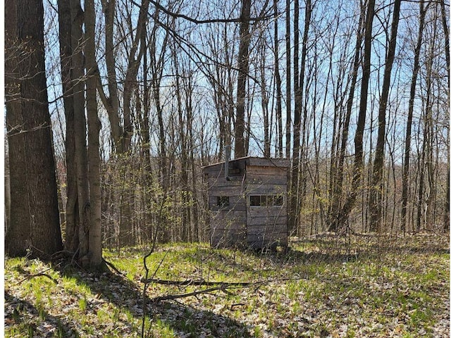 view of shed with a forest view